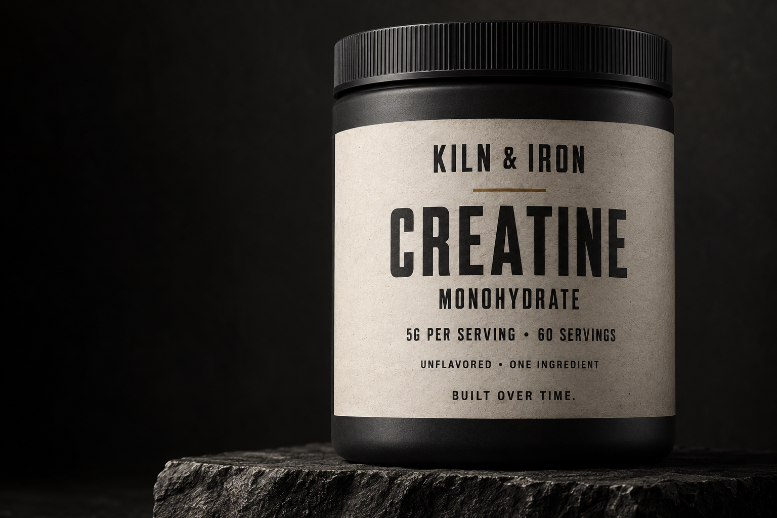 KILN & IRON Creatine Monohydrate in matte charcoal packaging on dark stone
